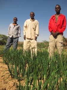 Ferhan (center) stands with fellow farmers from Ruqi who are learning new techniques on the demonstration plot.