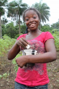 A youth learner prepares gari with water and sugar to feed her friends while working in the cassava field. A youth learner prepares gari with water and sugar to feed her friends while working in the cassava field.