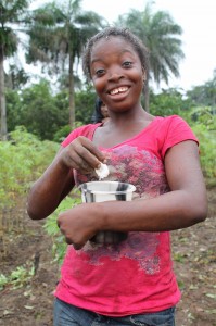 A youth learner prepares gari with water and sugar to feed her friends while working in the cassava field.